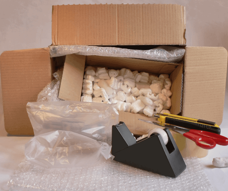 a box turned over with packaging inside, bubble wrap, and tape.