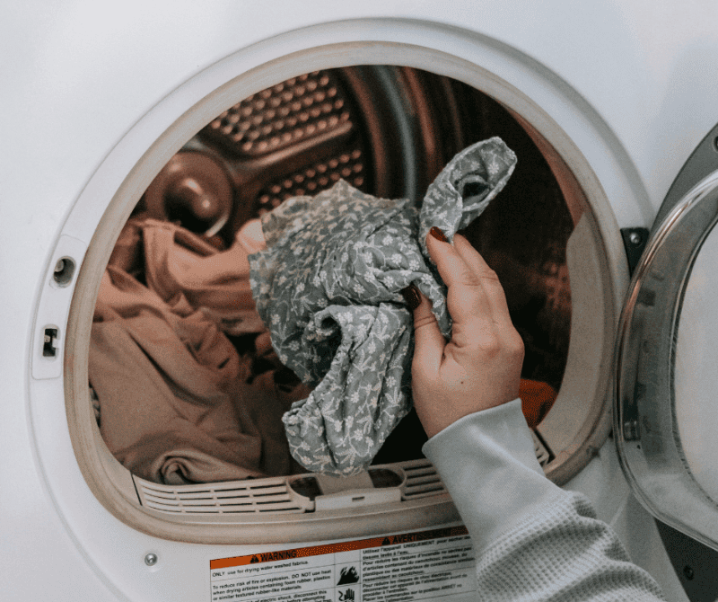 putting dirty clothes in washing machine