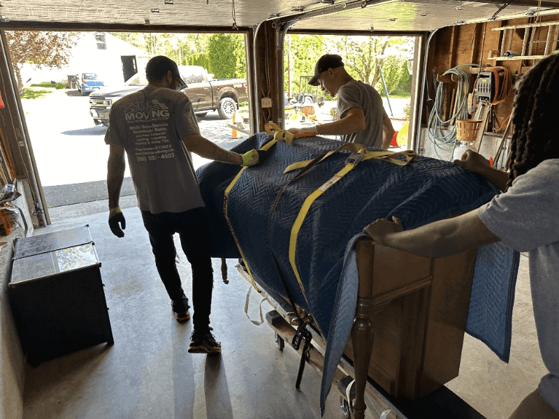 a crew of movers handling a precious grand piano with precision and care.