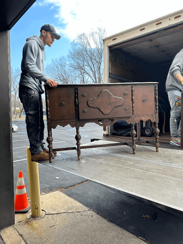 Moving crew carefully placing a furniture in the truck